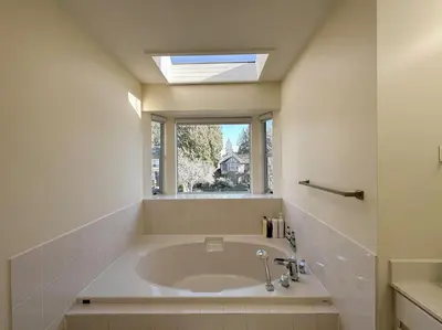 a bathroom with a large bath tub with a window at Super Cosy 8Bed & 6Bath in Vancouver heart near to airport and DownTown in Vancouver
