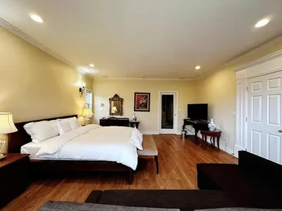 a bedroom with a large white bed and a piano at Super Cosy 8Bed & 6Bath in Vancouver heart near to airport and DownTown in Vancouver