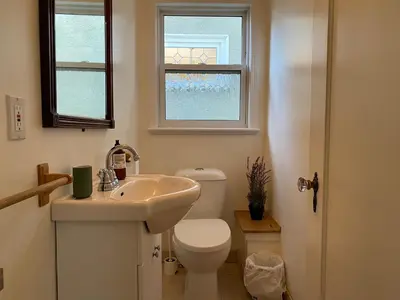 a bathroom with a toilet and a sink and a window at Cozy Dunbar 3 Beds Home w/ Views in Vancouver