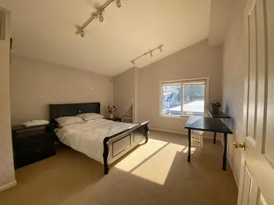 a bedroom with a bed and a desk and a window at Cozy Dunbar 3 Beds Home w/ Views in Vancouver