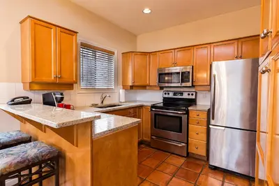 a kitchen with wooden cabinets and a stainless steel refrigerator at Villas at Eldorado Resort in Kelowna