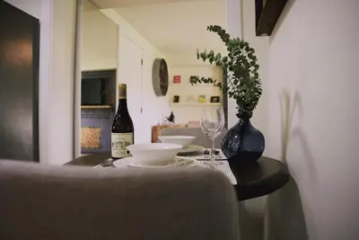 a table with a bottle of wine and two glasses at Guest Suite steps away from parks, trails & transit. in Port Coquitlam