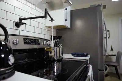 a kitchen with a stove with a pot on it at Guest Suite steps away from parks, trails & transit. in Port Coquitlam