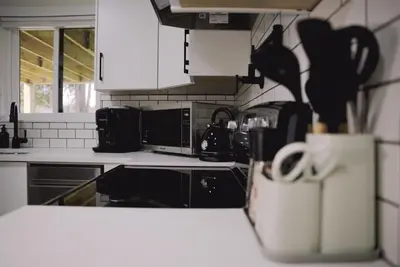 a kitchen with black and white appliances and a counter top at Guest Suite steps away from parks, trails & transit. in Port Coquitlam