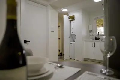 a kitchen with a table with a bottle of wine at Guest Suite steps away from parks, trails & transit. in Port Coquitlam