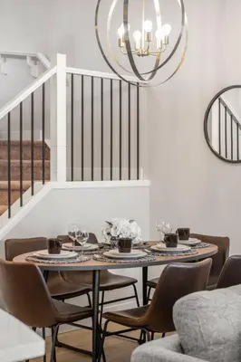 a dining room with a table and chairs and a chandelier at Stylish 3BR Townhouse by Airport in Calgary