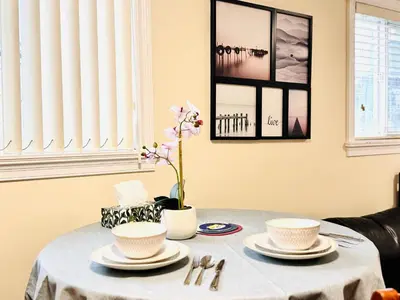 a dining room table with plates and bowls and a vase at Cozy 2 beds Spacious rooms,Close to transit in Vancouver