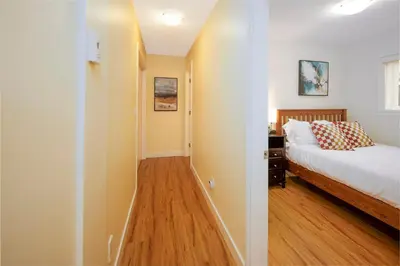 a small bedroom with a bed and a hallway at Cozy 2 beds Spacious rooms,Close to transit in Vancouver