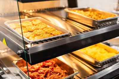 a buffet line with many trays of food at Home Inn and Suites Lloydminster in Lloydminster