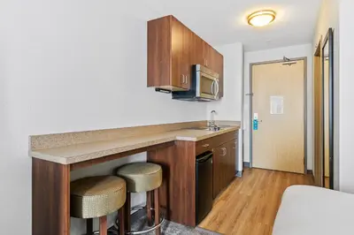 a kitchen with a counter and stools in a room at Home Inn and Suites Lloydminster in Lloydminster