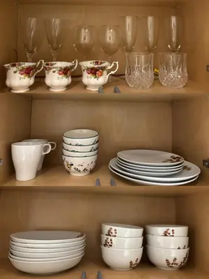 a shelf filled with plates and cups and dishes at Fancy Family Suite with Parking near UBC in Vancouver