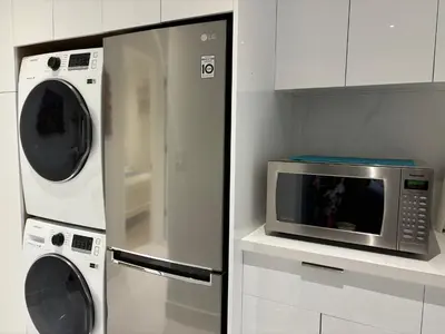 a kitchen with a microwave and a washer and dryer at Fancy Family Suite with Parking near UBC in Vancouver
