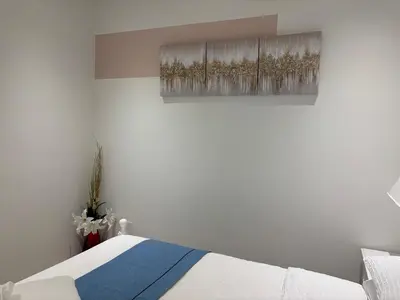 a bedroom with a bed and a painting on the wall at Fancy Family Suite with Parking near UBC in Vancouver