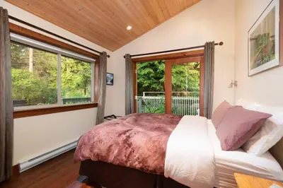 a bedroom with a bed and a window at Caboose in Bowen Island