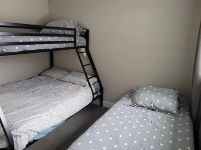 a small bedroom with two bunk beds and a bed at Lakeview B&B in Peachland