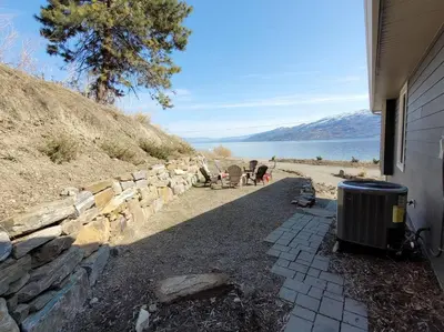 a trash can sitting outside of a house near the water at Lakeview B&B in Peachland