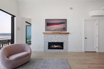 a living room with a chair and a fireplace at Beachfront Luxury Suite #18 at THE BEACH HOUSE in Campbell River