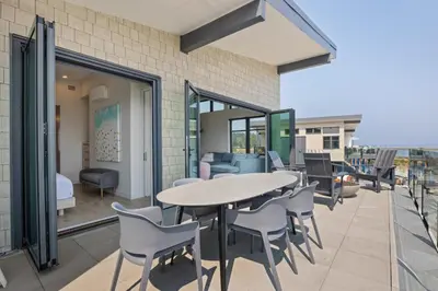 a patio with a table and chairs on a balcony at Beachfront Luxury Suite #18 at THE BEACH HOUSE in Campbell River