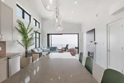 a kitchen and living room with a table and a dining room at Beachfront Luxury Suite #18 at THE BEACH HOUSE in Campbell River