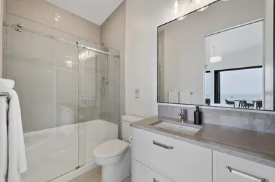 a bathroom with a toilet and a sink and a shower at Beachfront Luxury Suite #18 at THE BEACH HOUSE in Campbell River