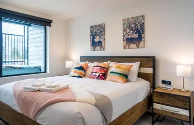 a bedroom with a large bed with a window at Alpine Dream by Revelstoke Vacations in Revelstoke