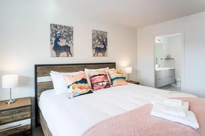 a bedroom with a large white bed with colorful pillows at Alpine Dream by Revelstoke Vacations in Revelstoke