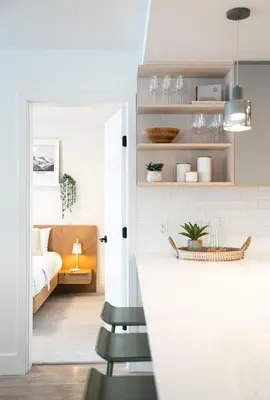 a room with a bed and a kitchen with a counter at Adanac by Revelstoke Vacations in Revelstoke