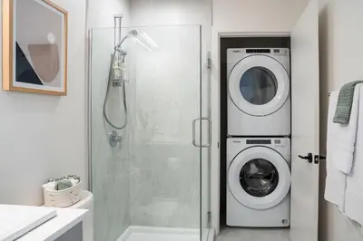 a bathroom with a washing machine in a shower at Adanac by Revelstoke Vacations in Revelstoke
