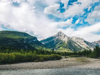 a river with a mountain in the background at Sundance By Basecamp in Kananaskis Village