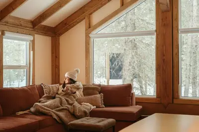 a man sitting on a couch with a dog at Sundance By Basecamp in Kananaskis Village