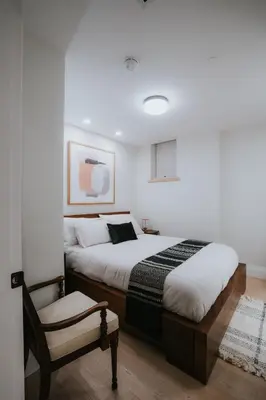 a bedroom with two beds and a chair at A Gentle Hideaway in the Urban Forest WEST END downtown Vancouver in Vancouver