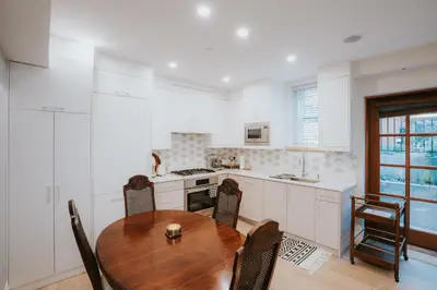 a kitchen with a wooden table and chairs in a kitchen at A Gentle Hideaway in the Urban Forest WEST END downtown Vancouver in Vancouver