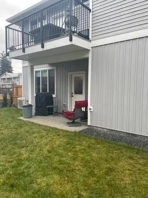 a patio with a balcony and two chairs on a house at Adorable 1 Bedroom Suite- a skip to Galloping Goose in Victoria