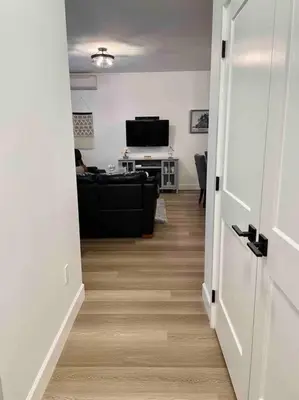 a hallway with a living room with a couch and a television at Adorable 1 Bedroom Suite- a skip to Galloping Goose in Victoria