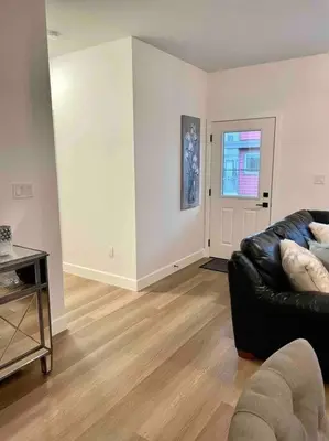 a living room with a black leather couch and a window at Adorable 1 Bedroom Suite- a skip to Galloping Goose in Victoria