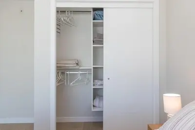 a bedroom with a closet with white walls at Live The Dream In The Haro in Saanichton