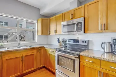 a kitchen with wooden cabinets and stainless steel appliances at Luxury Getaway at Copper Sky 104 in West Kelowna