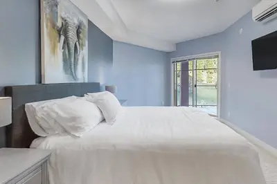 a blue bedroom with a large bed and a window at Luxury Getaway at Copper Sky 104 in West Kelowna