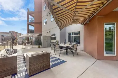 a patio with a table and chairs and a building at Luxury Getaway at Copper Sky 104 in West Kelowna