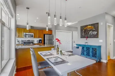 a kitchen with a white table and a blue island at Luxury Getaway at Copper Sky 104 in West Kelowna