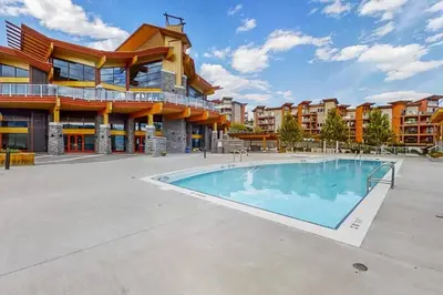a swimming pool in front of a building at Fabulous Condo at Five Star Resort 209 in West Kelowna