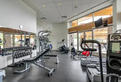 a gym with several treadmills and cardio machines at Fabulous Condo at Five Star Resort 209 in West Kelowna