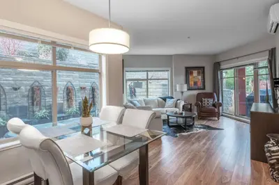 a living room with a glass table and white chairs at Fabulous Condo at Five Star Resort 209 in West Kelowna