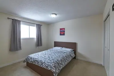 a bedroom with a bed and a window at Bowness Suites in Calgary
