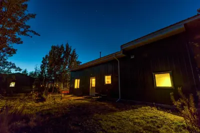 a building with its lights on at night at Yukon River Farm in Whitehorse