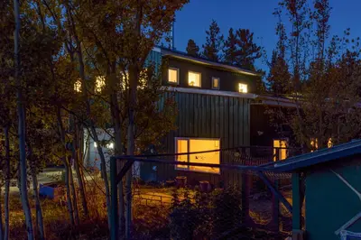 a house with its lights on at night at Yukon River Farm in Whitehorse