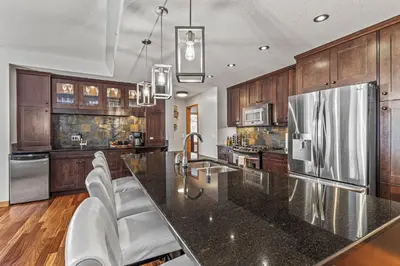 a kitchen with a large black counter top and wooden cabinets at 3 Bedroom Condo by Canadian Rockies Vacation Rentals in Canmore