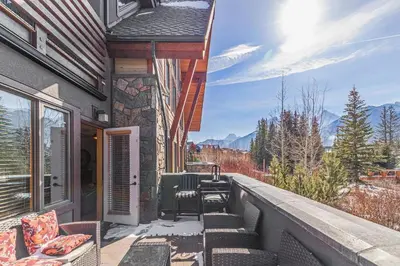 a balcony with chairs and a view of the mountains at 3 Bedroom Condo by Canadian Rockies Vacation Rentals in Canmore