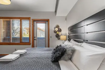 a bedroom with a large bed with a large headboard at 3 Bedroom Condo by Canadian Rockies Vacation Rentals in Canmore