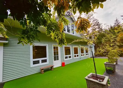 a house with a green lawn in front of it at Shambhala Zen Suite in Nanoose Bay
